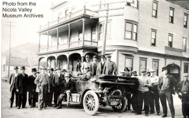 Early automobile and crowd outside a hotel, historic photograph