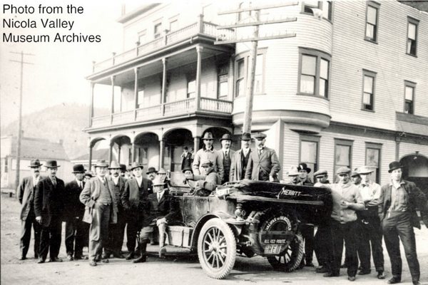 Early automobile and crowd outside a hotel, historic photograph